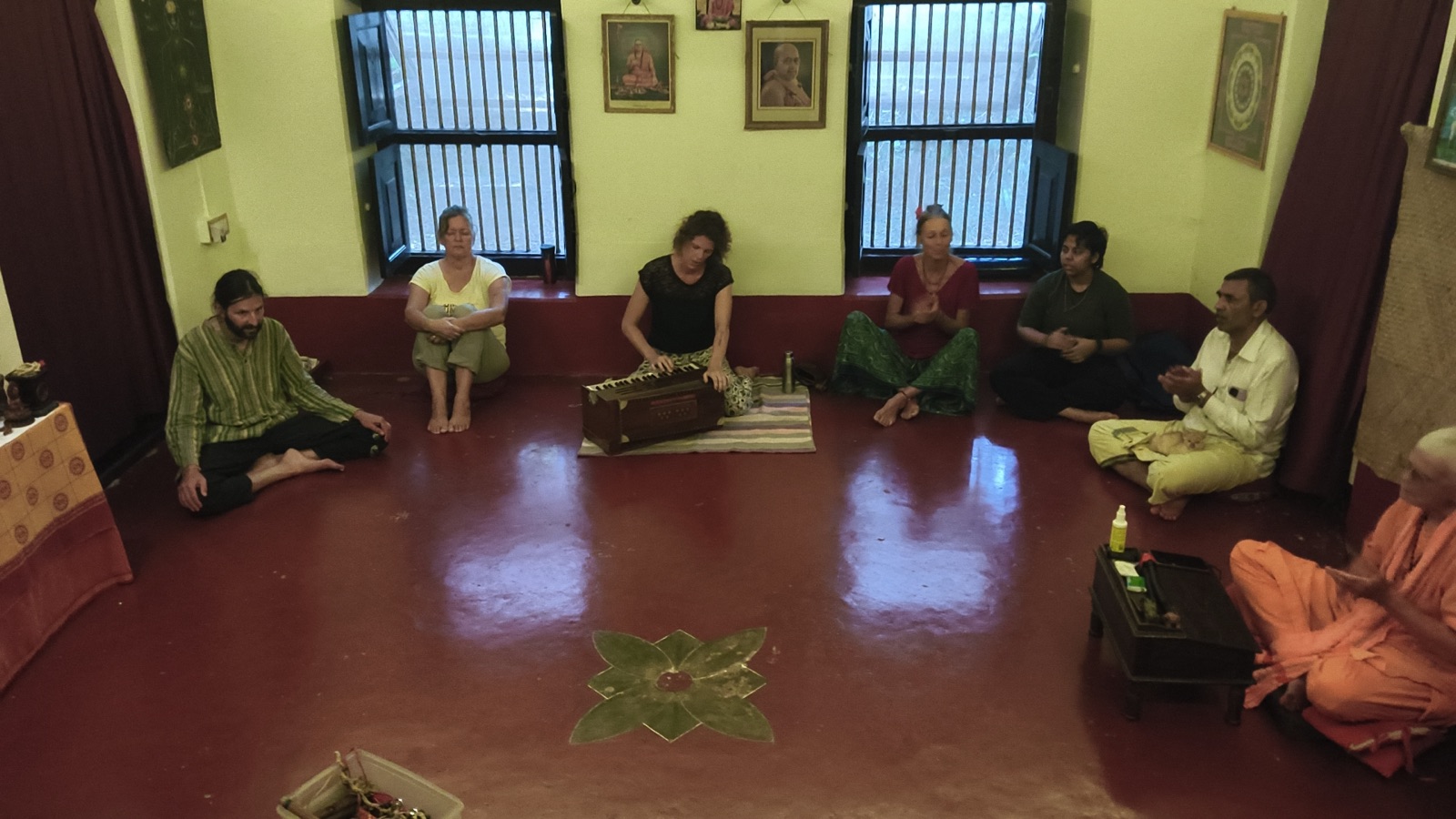 An evening kirtan circle with tanpura and harmonium